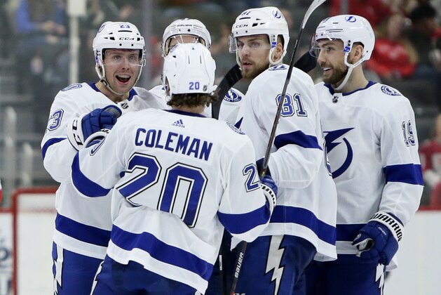 Tampa Bay Lightning center Carter Verhaeghe, left, celebrates with center Blake Coleman (20), defenseman Erik Cernak (81) and Barclay Goodrow after scoring against the Detroit Red Wings during the second period of an NHL hockey game Sunday, March 8, 2020, in Detroit. (AP Photo/Duane Burleson)