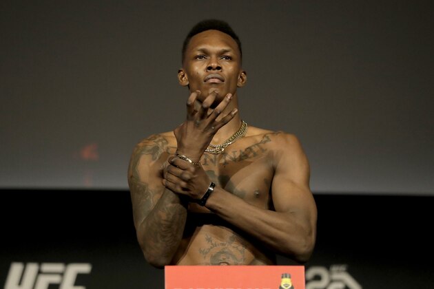 Israel Adesanya gestures while atop a scale during weigh-ins ahead of his mixed martial arts middleweight bout against Derek Brunson at UFC 230, Friday, Nov. 2, 2018, at Madison Square Garden in New York. (AP Photo/Julio Cortez)