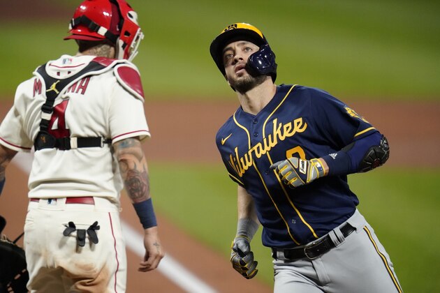 Milwaukee Brewers' Ryan Braun, right, scores past St. Louis Cardinals catcher Yadier Molina after hitting a solo home run during the fourth inning of a baseball game Saturday, Sept. 26, 2020, in St. Louis. (AP Photo/Jeff Roberson)