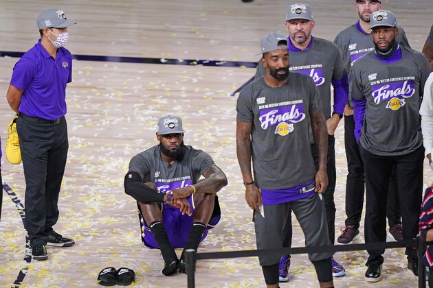 Los Angeles Lakers' LeBron James sits on the floor as he waits for the trophy ceremony to start after the Lakers beat the Denver Nuggets in an NBA conference final playoff basketball game Saturday, Sept. 26, 2020, in Lake Buena Vista, Fla. The Lakers won 117-107 to win the series 4-1. (AP Photo/Mark J. Terrill)