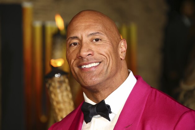 FILE - In this Dec. 5, 2019 file photo, actor Dwayne Johnson poses for photographers upon arrival at the premiere of the film 'Jumanji The Next Level', in central London.   Johnson will revisit his younger years in a new NBC comedy series called “The Rock,” which is the retired pro wrestler's nickname. NBC said Saturday, Jan. 11, 2020  that it's ordered 11 episodes of the show inspired by Johnson, who will appear and also serve as an executive producer.  (Photo by Joel C Ryan/Invision/AP)