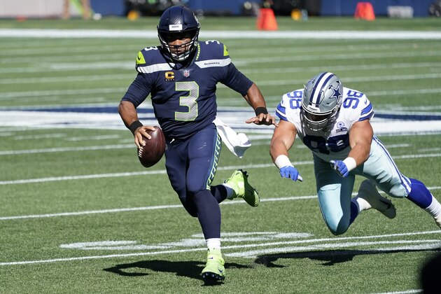 Seattle Seahawks quarterback Russell Wilson (3) scrambles away from Dallas Cowboys defensive tackle Tyrone Crawford during the first half of an NFL football game, Sunday, Sept. 27, 2020, in Seattle. (AP Photo/Elaine Thompson)