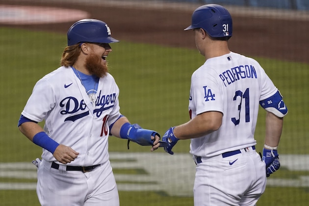 Los Angeles Dodgers' Justin Turner, left, celebrates with Joc Pederson after scoring due to a single by Will Smith during the first inning of a baseball game against the Los Angeles Angels, Saturday, Sept. 26, 2020, in Los Angeles. (AP Photo/Ashley Landis)