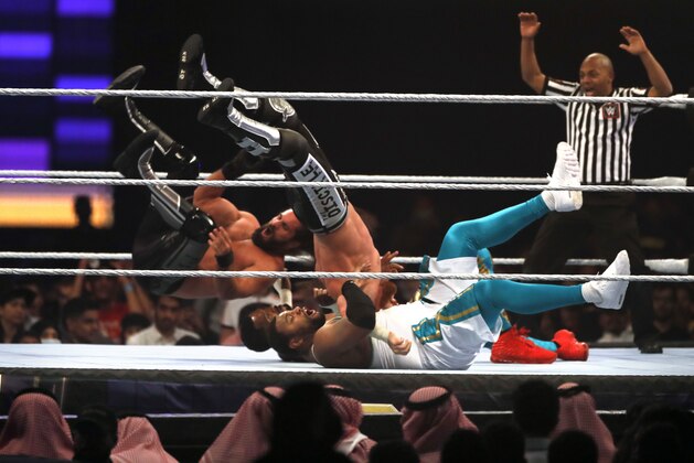 Seth Rollins and Murphy, left and center, in action against The Street Prophets at WWE Super ShowDown in Riyadh, Saudi Arabia, late Thursday, Feb. 27, 2020. (AP Photo/Amr Nabil)