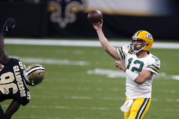 Green Bay Packers quarterback Aaron Rodgers (12) passes under pressure from New Orleans Saints defensive end Carl Granderson (96) in the first half of an NFL football game in New Orleans, Sunday, Sept. 27, 2020. (AP Photo/Butch Dill)
