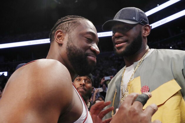 Miami Heat guard Dwyane Wade, left, chats with LeBron James before the Heat's NBA basketball game against the Brooklyn Nets, Wednesday, April 10, 2019, in New York. Wade is retiring after the game. (AP Photo/Kathy Willens)