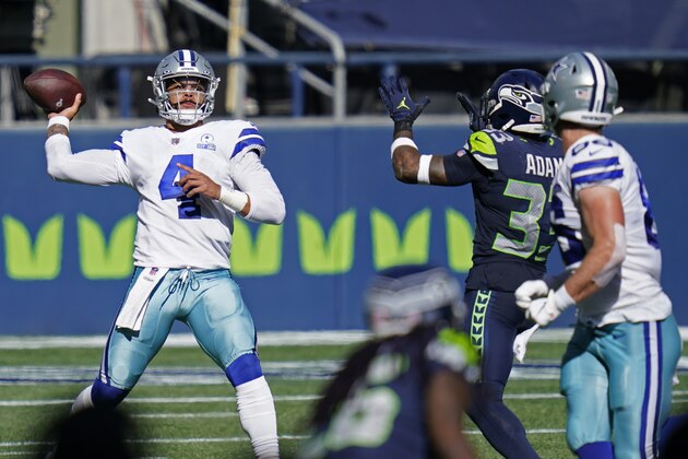 Dallas Cowboys quarterback Dak Prescott (4) passes under pressure from Seattle Seahawks strong safety Jamal Adams, second from right, during the first half of an NFL football game, Sunday, Sept. 27, 2020, in Seattle. (AP Photo/Elaine Thompson)