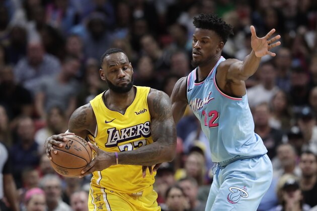 Miami Heat forward Jimmy Butler (22) defends Los Angeles Lakers forward LeBron James during the second half of an NBA basketball game, Friday, Dec. 13, 2019, in Miami. The Lakers won 113-110. (AP Photo/Lynne Sladky)