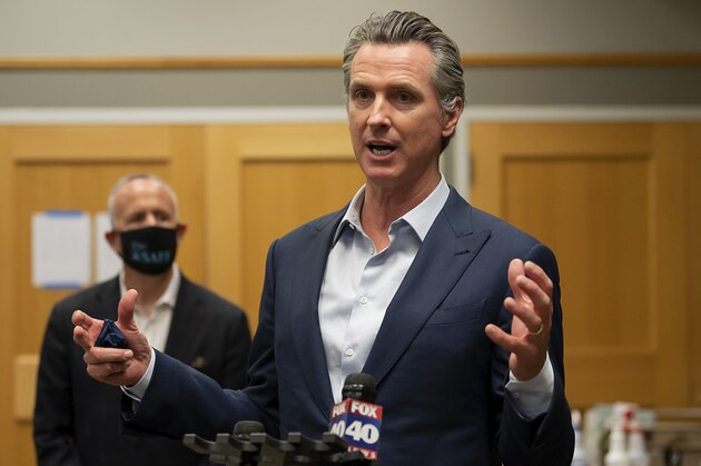 California Gov. Gavin Newsom speaks during a tour of a cooling center with Sacramento Mayor Darrell Steinberg, at the Tsakopoulos Library Galleria on Tuesday, Aug. 18, 2020, in Sacramento, Calif. Newsom declared an emergency Tuesday over wildfires burning throughout California as the state's power grid operator pleaded with residents and businesses to continue conserving energy to avoid rolling blackouts. (Paul Kitagaki Jr./The Sacramento Bee via AP, Pool)