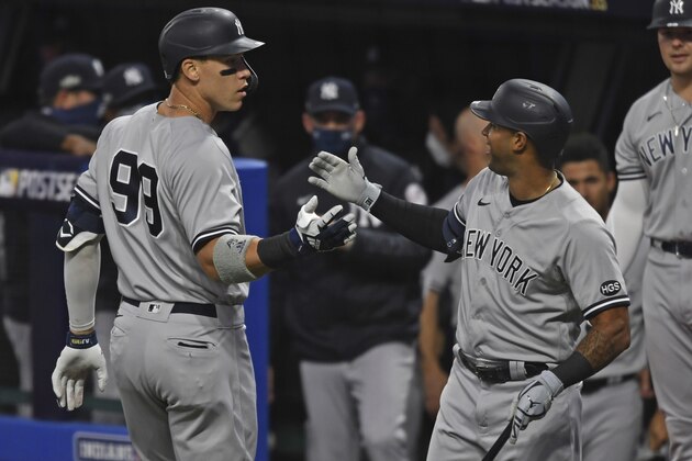 New York Yankees' Aaron Judge (99) is congratulated by Aaron Hicks after hitting a two-run home run off Cleveland Indians starting pitcher Shane Bieber (57) in the first inning of Game 1 of an American League wild-card baseball series, Tuesday, Sept. 29, 2020, in Cleveland. (AP Photo/David Dermer)