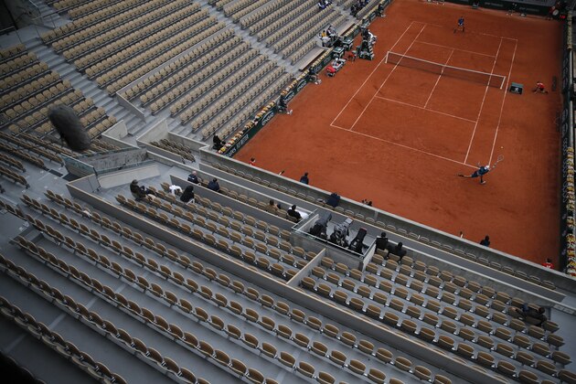 A near-empty Suzanne Lenglen court hosts the first round match of the French Open tennis tournament between Italy's Matteo Berrettini, close side, and Canada's Vasek Pospisil, far side, at the Roland Garros stadium in Paris, France, Tuesday, Sept. 29, 2020. (AP Photo/Christophe Ena)