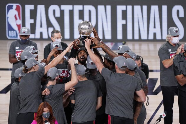 The Miami Heat celebrate their NBA conference final playoff basketball game win over the Boston Celtics with the Eastern Final trophy Sunday, Sept. 27, 2020, in Lake Buena Vista, Fla. (AP Photo/Mark J. Terrill)