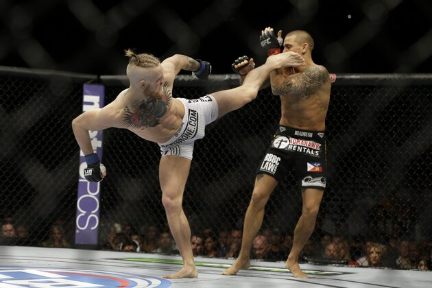 Conor McGregor, left, kicks Dustin Poirier, during their fight, Saturday, Sept. 27, 2014, in Las Vegas. McGregor won via TKO. (AP Photo/John Locher)