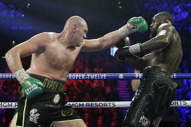FILE - In this Feb. 22, 2020, file photo, Tyson Fury, left, of England, fights Deontay Wilder during a WBC heavyweight championship boxing match in Las Vegas. An all-British world heavyweight title showdown between Anthony Joshua and Tyson Fury in 2021 is a step closer. Fury said Wednesday, June 10, 2020, that an agreement has been reached with Joshua's camp on a two-fight deal between the current holders of the heavyweight belts.(AP Photo/Isaac Brekken, File)