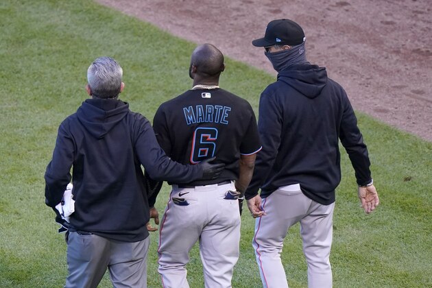 A member of the Miami Marlins staff and manager Don Mattingly, right, lead Starling Marte (6) away after Marte was hit by a pitch in the ninth inning of Game 1 of a National League wild-card baseball series against the Chicago Cubs in Chicago, Wednesday, Sept. 30, 2020. Marte left the game with an unknown injury. (AP Photo/Nam Y. Huh)