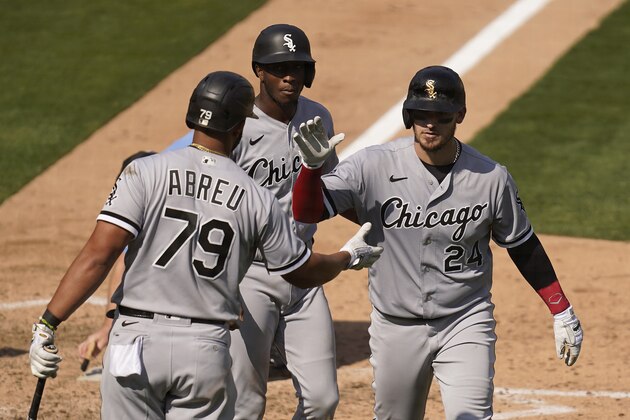 Chicago White Sox's Yasmani Grandal, right, is congratulated by Jose Abreu (79) after hitting a two-run home run that scored Tim Anderson, rear, during the eighth inning of Game 2 of an American League wild-card baseball series against the Oakland Athletics Wednesday, Sept. 30, 2020, in Oakland, Calif. (AP Photo/Eric Risberg)