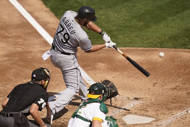 Chicago White Sox's Jose Abreu, top, hits a two-run home run in front of Oakland Athletics catcher Sean Murphy, bottom right, during the third inning of Game 1 of an American League wild-card baseball series Tuesday, Sept. 29, 2020, in Oakland, Calif. Also pictured is umpire Adam Hamari. (AP Photo/Eric Risberg)