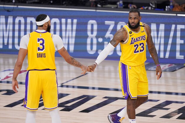 Los Angeles Lakers' Anthony Davis (3) and LeBron James (23) shake hands after beating the Denver Nuggets an NBA conference final playoff basketball game Thursday, Sept. 24, 2020, in Lake Buena Vista, Fla. (AP Photo/Mark J. Terrill)