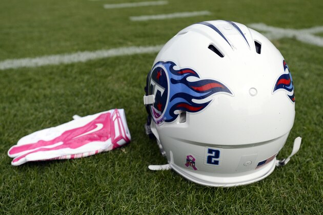 A pink glove lies next to a Tennessee Titans helmet bearing a breast cancer awareness logo and a sticker showing the No. 2 uniform number of former Titans kicker Rob Bironas before an NFL football game against the Cleveland Browns Sunday, Oct. 5, 2014, in Nashville, Tenn. Bironas died in a car crash Sept. 20.(AP Photo/Mark Zaleski)