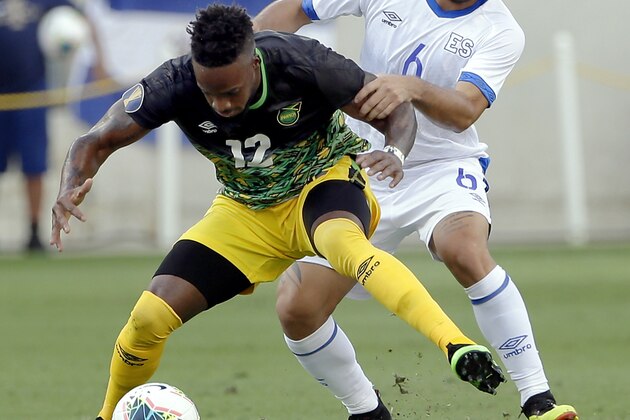 Jamaica forward Junior Flemmings (12) is held back by El Salvador midfielder Narciso Orellana (6) during the first half of a CONCACAF Gold Cup soccer match Friday, June 21, 2019, in Houston. (AP Photo/Michael Wyke)