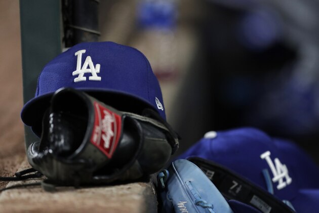 Los Angeles Dodgers hats are seen near gloves in the dugout during the eighth inning of a baseball game against the Baltimore Orioles, Tuesday, Sept. 10, 2019, in Baltimore. The Orioles won 7-3. (AP Photo/Julio Cortez)
