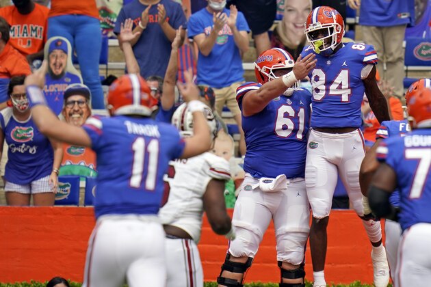 Florida tight end Kyle Pitts (84) celebrates his touchdown catch from quarterback Kyle Trask (11) with offensive lineman Brett Heggie (61) during the first half of an NCAA college football game against South Carolina, Saturday, Oct. 3, 2020, in Gainesville, Fla. (AP Photo/John Raoux,Pool) Florida tight end Kyle Pitts (84) celebrates his touchdown catch from quarterback Kyle Trask (11) with offensive lineman Brett Heggie (61) during the first half of an NCAA college football game against South Carolina, Saturday, Oct. 3, 2020, in Gainesville, Fla. (AP Photo/John Raoux,Pool)