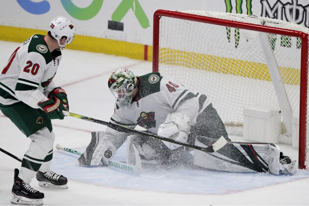Minnesota Wild goaltender Devan Dubnyk (40) blocks a shot with defenseman Ryan Suter (20) watching during the third period of an NHL hockey game against the Anaheim Ducks in Anaheim, Calif., Sunday, March 8, 2020. (AP Photo/Alex Gallardo)