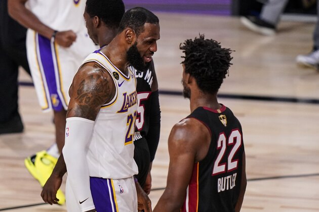 Los Angeles Lakers' LeBron James (23) talks to Miami Heat's Jimmy Butler (22) during the first half in Game 3 of basketball's NBA Finals, Sunday, Oct. 4, 2020, in Lake Buena Vista, Fla. (AP Photo/Mark J. Terrill)