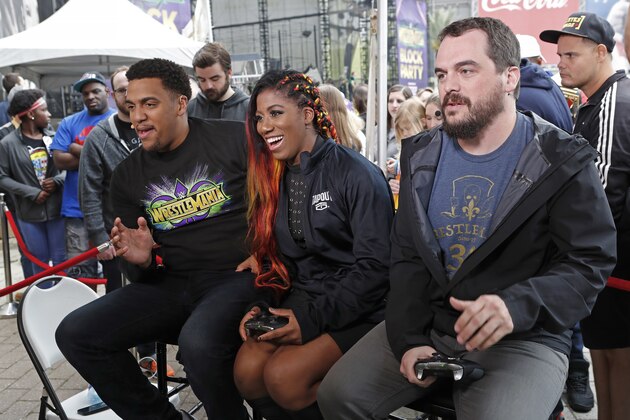IMAGE DISTRIBUTED FOR XBOX - Ember Moon, Rukari Austin, and Bryan Vore play WWE 2K 18 on Xbox One X from Wrestlemania 34 on Sunday, April 8, 2018, in New Orleans. (Tyler Kaufman/AP Images for Xbox)