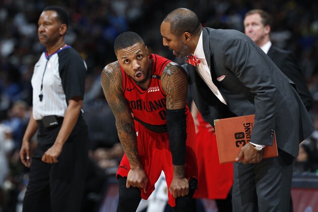Portland Trail Blazers assistant coach David Vanterpool, right, confers with guard Damian Lillard during a break in the action in the second half of Game 2 of the team's NBA basketball second-round playoff series  against the Denver Nuggets on Wednesday, May 1, 2019, in Denver. Portland won 97-90. (AP Photo/David Zalubowski)