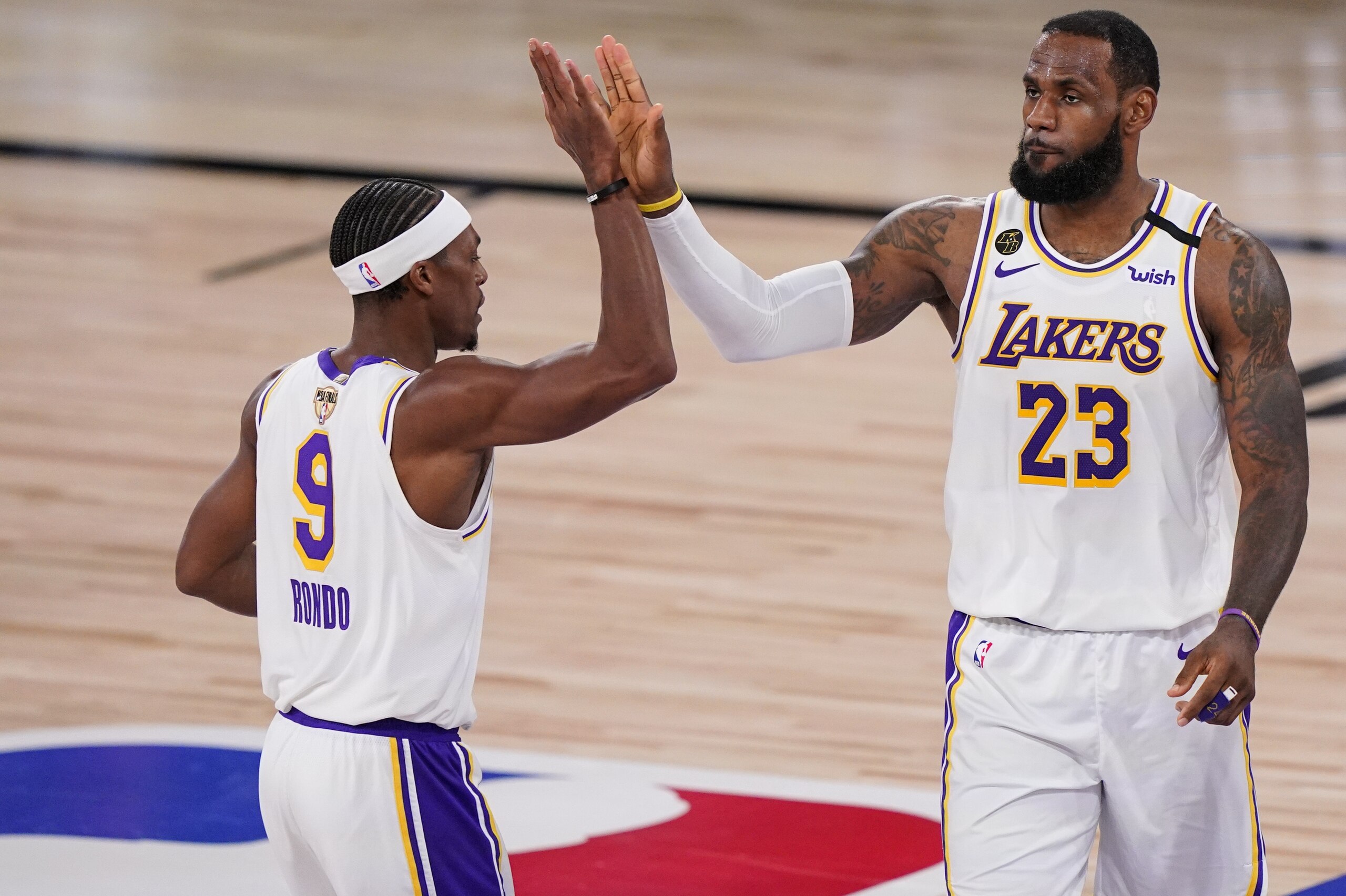 Los Angeles Lakers' LeBron James (23) high fives Los Angeles Lakers' Rajon Rondo (9) during the second half in Game 3 of basketball's NBA Finals, Sunday, Oct. 4, 2020, in Lake Buena Vista, Fla. (AP Photo/Mark J. Terrill)