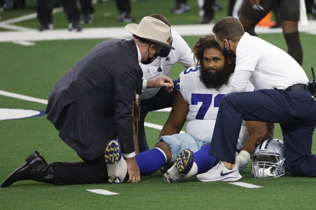 Dallas Cowboys center Joe Looney (73) is looked at by team staff in an NFL football game against the Cleveland Browns in Arlington, Texas, Sunday, Oct. 4, 2020.(AP Photo/Ron Jenkins)