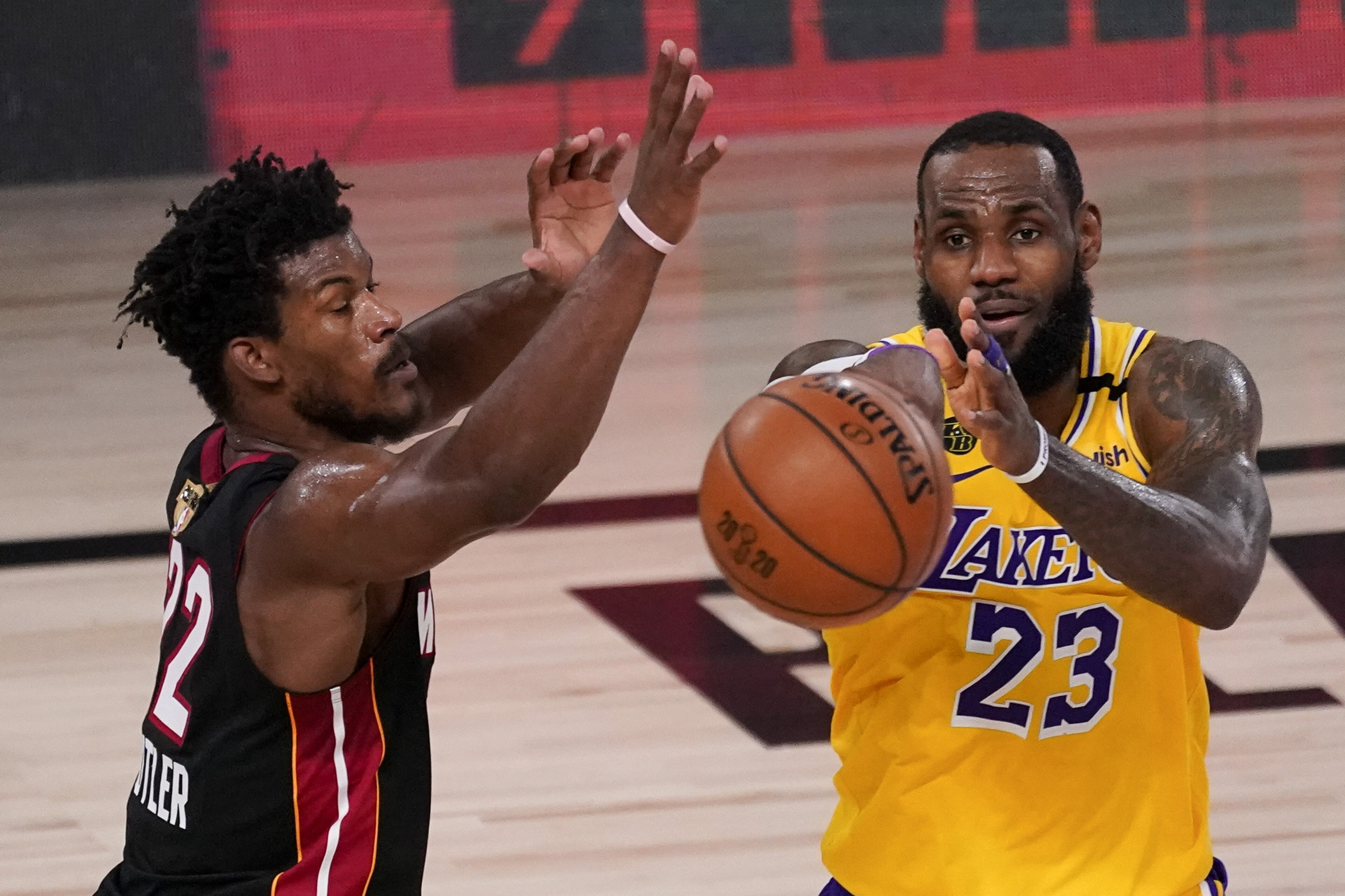 Los Angeles Lakers forward LeBron James, right, passes around Miami Heat forward Jimmy Butler during the second half in Game 4 of basketball's NBA Finals Tuesday, Oct. 6, 2020, in Lake Buena Vista, Fla. (AP Photo/John Raoux) Los Angeles Lakers forward LeBron James, right, passes around Miami Heat forward Jimmy Butler during the second half in Game 4 of basketball's NBA Finals Tuesday, Oct. 6, 2020, in Lake Buena Vista, Fla. (AP Photo/John Raoux)