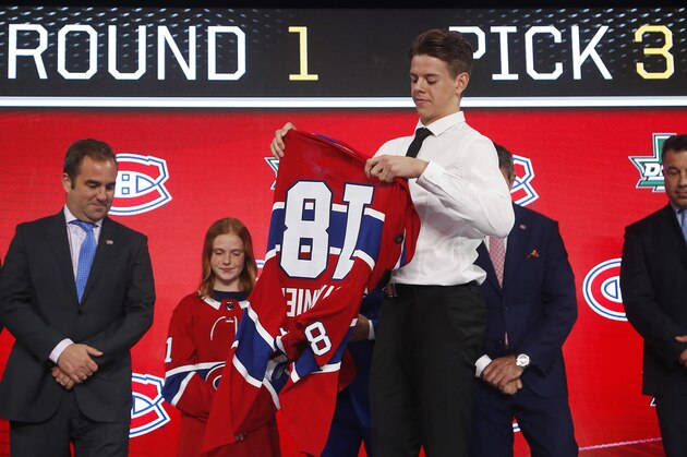CORRECTS TO MONTREAL CANADIENS NOT CAROLINA HURRICANES Jesperi Kotkaniemi, of Finland, puts on a jersey after being selected by the Montreal Canadiens during the NHL hockey draft in Dallas, Friday, June 22, 2018. (AP Photo/Michael Ainsworth) CORRECTS TO MONTREAL CANADIENS NOT CAROLINA HURRICANES Jesperi Kotkaniemi, of Finland, puts on a jersey after being selected by the Montreal Canadiens during the NHL hockey draft in Dallas, Friday, June 22, 2018. (AP Photo/Michael Ainsworth)