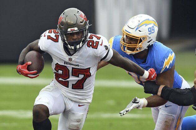 Tampa Bay Buccaneers running back Ronald Jones (27) gets away from Los Angeles Chargers defensive tackle Jerry Tillery (99) during the first half of an NFL football game Sunday, Oct. 4, 2020, in Tampa, Fla. (AP Photo/Jason Behnken)