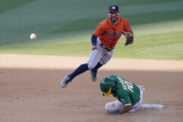 Houston Astros second baseman Jose Altuve, top, throws to first base after forcing out Oakland Athletics' Marcus Semien (10) at second base on a double play hit into by Chad Pinder during the ninth inning of Game 2 of a baseball American League Division Series in Los Angeles, Tuesday, Oct. 6, 2020. (AP Photo/Ashley Landis)