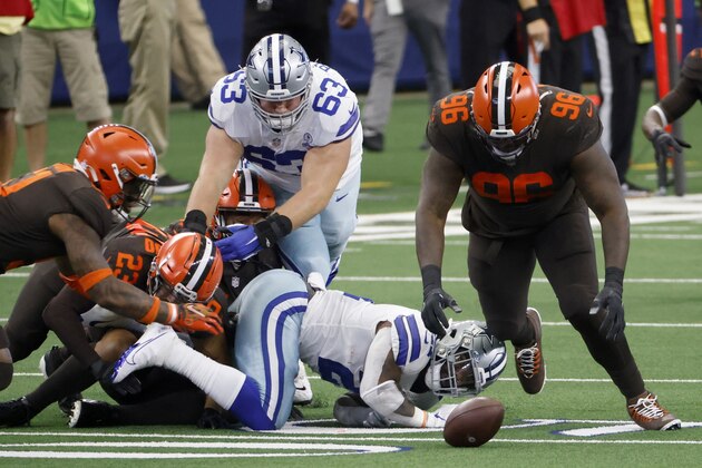 Dallas Cowboys running back Ezekiel Elliott, bottom center, fumbles the ball as Cleveland Browns' Andrew Sendejo (23), Vincent Taylor (96) and others race after the loose ball in the first half of an NFL football game in Arlington, Texas, Sunday, Oct. 4, 2020. The Browns recovered the ball. (AP Photo/Ron Jenkins)