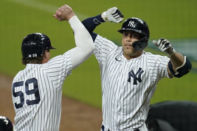 New York Yankees' Luke Voit, left, celebrates with Giancarlo Stanton after Stanton hit a home run scoring Voit against the Tampa Bay Rays during the eighth inning in Game 3 of a baseball American League Division Series, Wednesday, Oct. 7, 2020, in San Diego. (AP Photo/Gregory Bull)