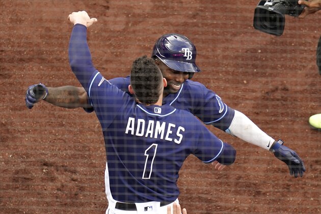 Tampa Bay Rays' Randy Arozarena, right, hugs Willy Adames (1) after Arozarena hit a solo home run during the first inning in Game 2 of a baseball American League Division Series against the New York Yankees, Tuesday, Oct. 6, 2020, in San Diego. (AP Photo/Gregory Bull)