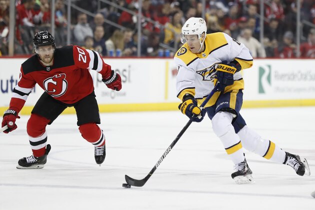 New Jersey Devils center Blake Coleman (20) defends as Nashville Predators center Kyle Turris (8) skates with the puck during the first period of an NHL hockey game, Thursday, Jan. 30, 2020, in Newark, N.J. (AP Photo/Kathy Willens)