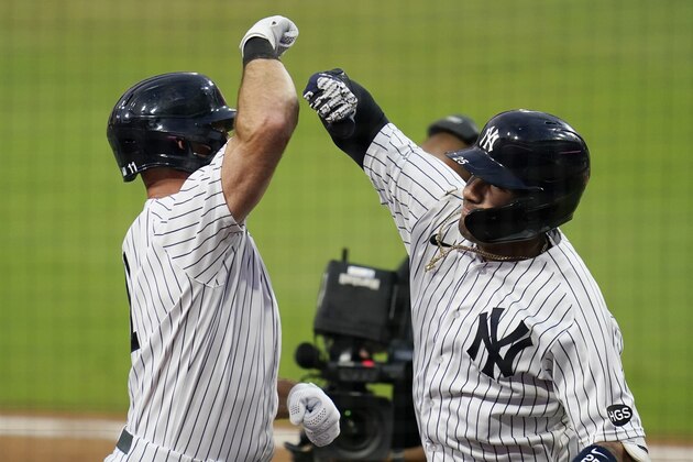 New York Yankees' Gleyber Torres, right, celebrates with Brett Gardner, left, after Torres hit a two-run home run to score Gardner during the sixth inning in Game 4 of a baseball American League Division Series against the Tampa Bay Rays, Thursday, Oct. 8, 2020, in San Diego. (AP Photo/Gregory Bull)