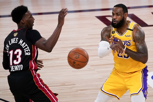 Los Angeles Lakers forward LeBron James, right, passes around Miami Heat forward Bam Adebayo during the second half in Game 4 of basketball's NBA Finals Tuesday, Oct. 6, 2020, in Lake Buena Vista, Fla. (AP Photo/John Raoux)