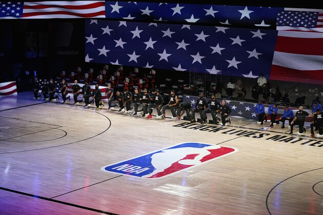 Players, coaches and staff of the Los Angeles Lakers and the Houston Rockets kneel during the national anthem before the first half of an NBA conference semifinal playoff basketball game Sunday, Sept. 6, 2020, in Lake Buena Vista, Fla. (AP Photo/Mark J. Terrill)