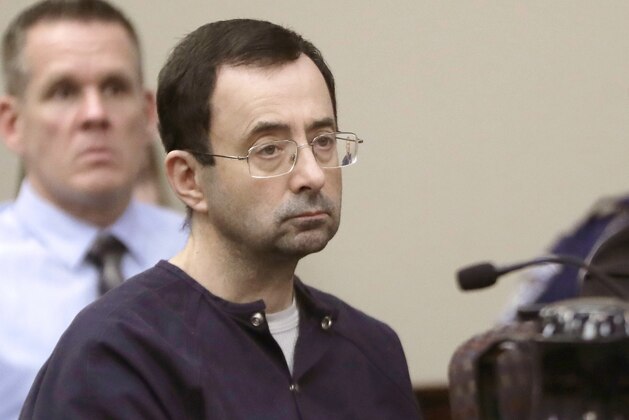 FILE - In this Jan. 24, 2018, file photo, Larry Nassar, a former doctor for USA Gymnastics and member of Michigan State's sports medicine staff, sits in court during his sentencing hearing in Lansing, Mich. MSU is defending itself against a second wave of lawsuits related to Nassar but says it wants to reach a deal with the additional assault victims. MSU defended itself in a court filing Monday, Aug. 26, 2019. It says it's immune to liability for Nassar's crimes, no matter how