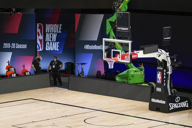 Crews work on a basketball arena at ESPN Wide World of Sports Complex, Wednesday, July 29, 2020, in Orlando, Fla. NBA games will resume Thursday. (AP Photo/Ashley Landis)