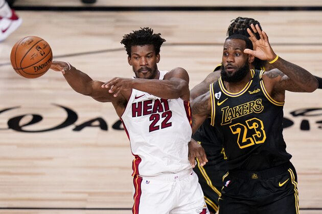 Miami Heat forward Jimmy Butler, left, passes around Los Angeles Lakers forward LeBron James during the first half in Game 5 of basketball's NBA Finals Friday, Oct. 9, 2020, in Lake Buena Vista, Fla. (AP Photo/John Raoux)