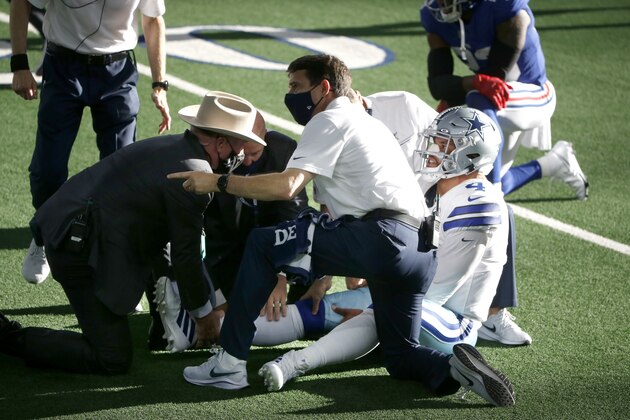 Dallas Cowboys quarterback Dak Prescott, right, is receives medical assistance from first responders and team medical personnel after Prescott suffered a lower right leg injury running the ball against the New York Giants in the second half of an NFL football game in Arlington, Texas, Sunday, Oct. 11, 2020. (AP Photo/Michael Ainsworth)