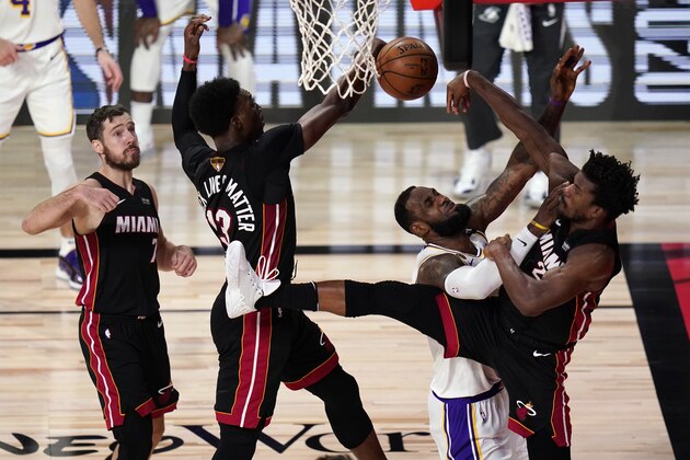Miami Heat's Bam Adebayo (13) and Jimmy Butler (22) rejects a shot by Los Angeles Lakers' LeBron James (23) during the first half in Game 6 of basketball's NBA Finals Sunday, Oct. 11, 2020, in Lake Buena Vista, Fla. (AP Photo/John Raoux)