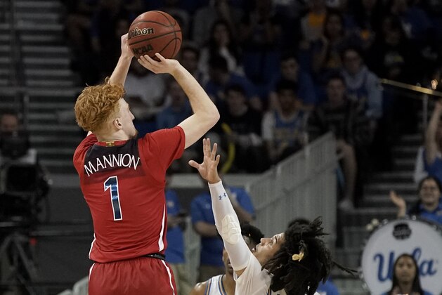 Arizona guard Nico Mannion, left, shoots over UCLA guard Tyger Campbell during the second half of an NCAA college basketball game in Los Angeles, Saturday, Feb. 29, 2020. UCLA won 69-64. (AP Photo/Chris Carlson)