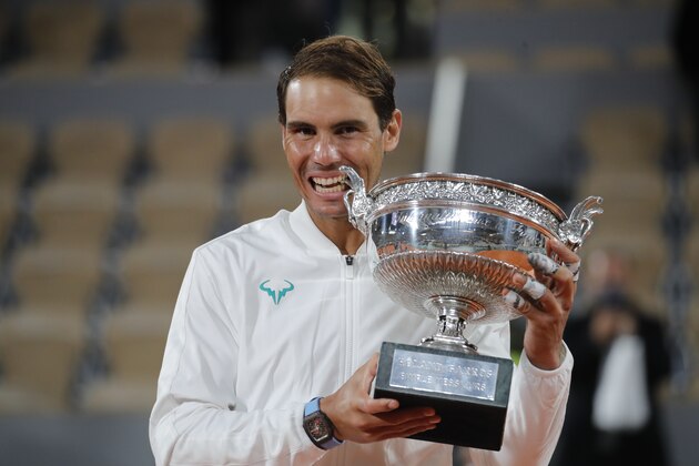 Spain's Rafael Nadal bites the trophy as he celebrates winning the final match of the French Open tennis tournament against Serbia's Novak Djokovic in three sets, 6-0, 6-2, 7-5, at the Roland Garros stadium in Paris, France, Sunday, Oct. 11, 2020. (AP Photo/Christophe Ena)